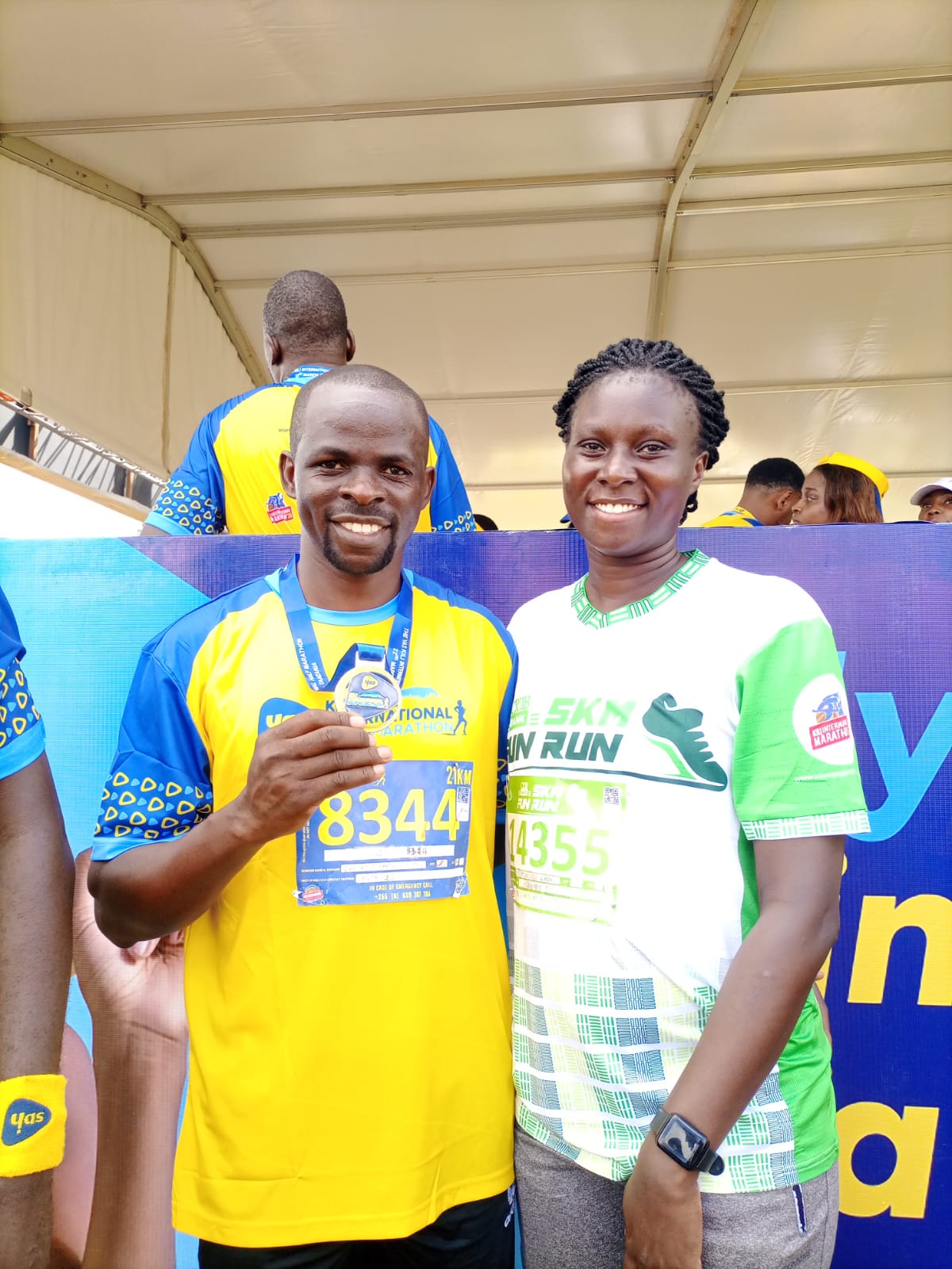 Two Afyafit participants showing their half marathon medals
